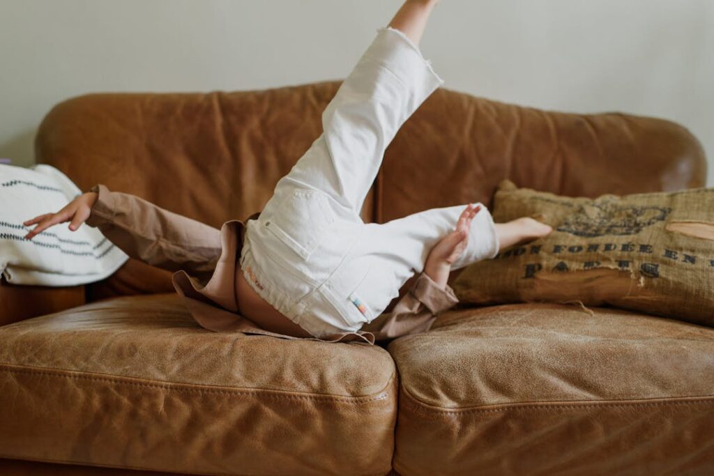 A child plays on a leather sofa