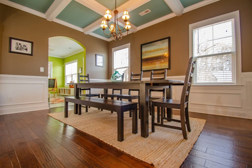 A dining area with a hardwood floor and a rug